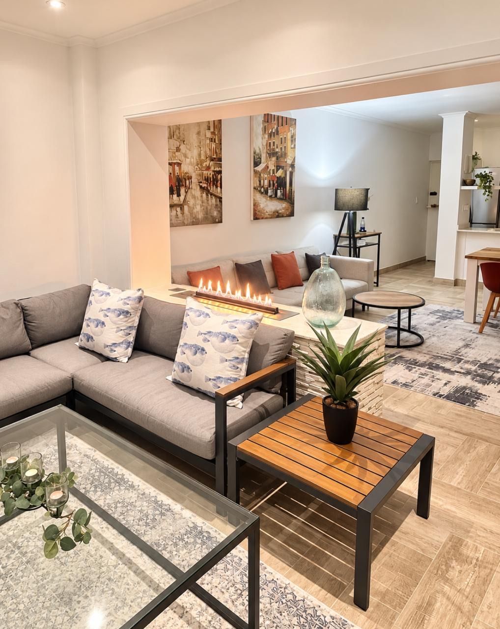 A modern living room with a sofa, coffee table, and a fireplace.