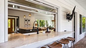 Une cuisine moderne dotée d’un grand îlot central, de tabourets de bar et d’un coin repas avec un canapé.