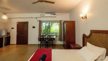 Una habitación de hotel con cama, escritorio y ventana con vistas a zonas verdes.