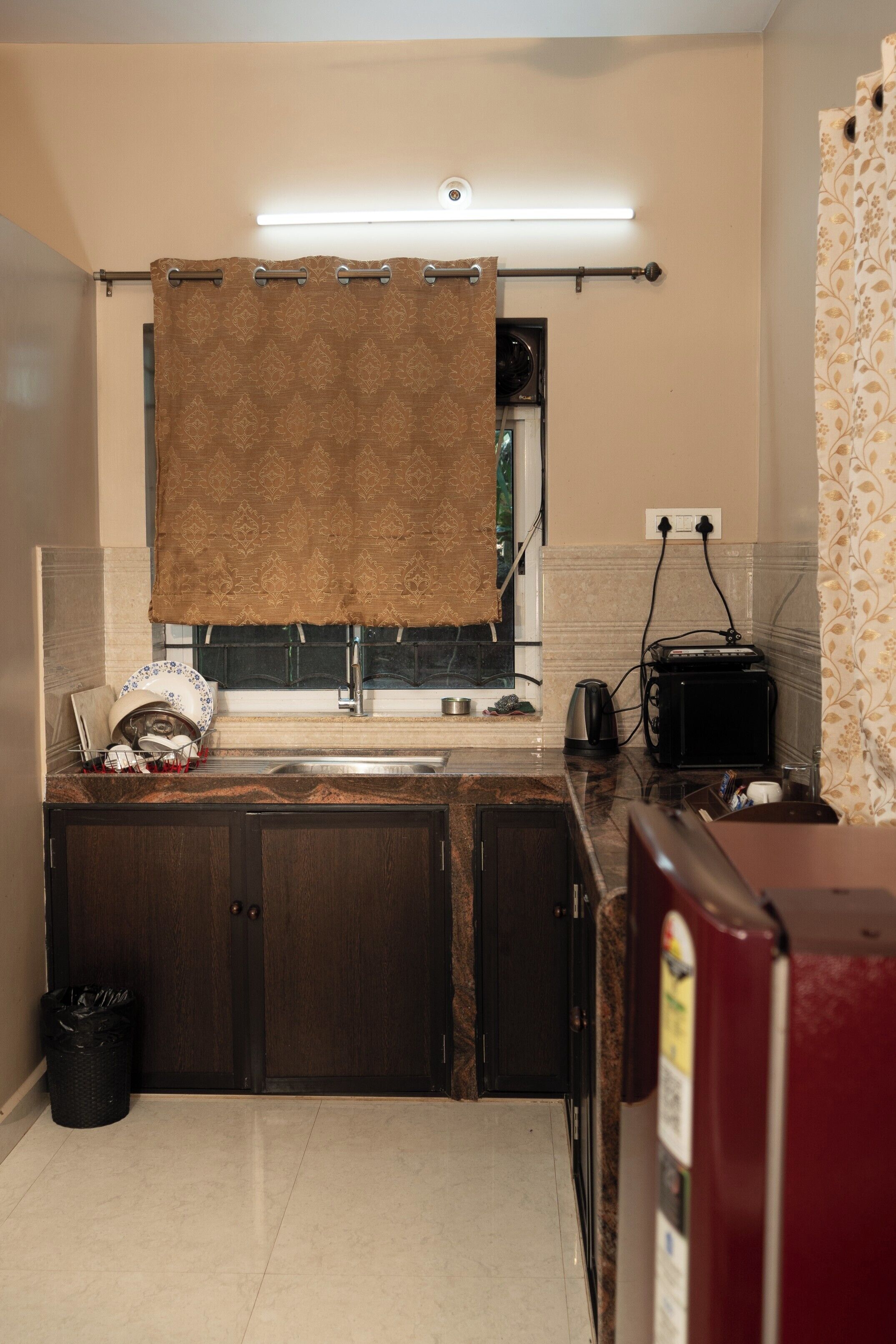 A compact kitchen with a sink, a toaster, and a refrigerator.