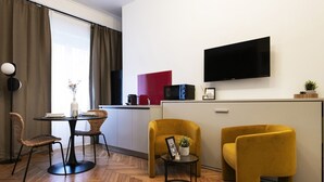 A modern living room with a dining area, a flat-screen TV mounted on the wall, and a kitchen area with a red accent wall. - Easylife-Sophisticated  with Jacuzzi in Centrale (Milano)