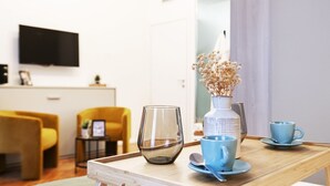 A wooden table with a clear glass, a white vase with dried flowers, and two blue cups with saucers. - Easylife-Sophisticated  with Jacuzzi in Centrale (Milano)
