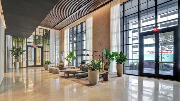 A spacious lobby with a polished floor, large windows, and potted plants. - NEW Stunning 2/2 with Panoramic Views of Miami PH Condo 50th floor (Miami)