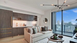 A modern living room with a sofa, coffee table, and city view. - NEW Stunning 2/2 with Panoramic Views of Miami PH Condo 50th floor (Miami)