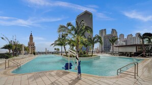 A swimming pool with a palm tree and a cityscape in the background. - NEW Stunning 2/2 with Panoramic Views of Miami PH Condo 50th floor (Miami)