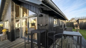 A modern house with a deck, large windows, and outdoor furniture. - Stunning home in Haderslev with WiFi (Haderslev)