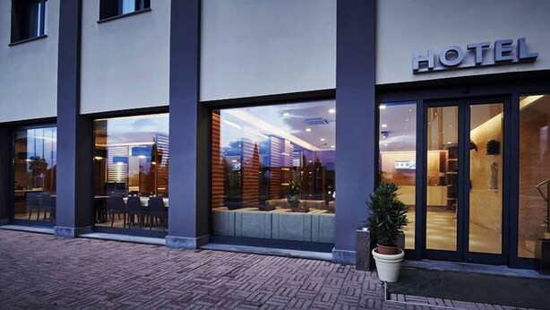 A hotel with a modern exterior, large glass windows, and a sign indicating it is a hotel. - Hotel PisaValdera (Pontedera)