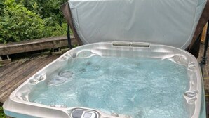 Ein Whirlpool mit Holzverkleidung und einer Bedieneinheit an der Seite.