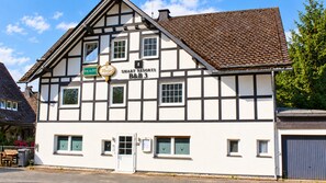 A traditional half-timbered building with a sign for 'SMART RESORTS B&B 3' and a beer sign.