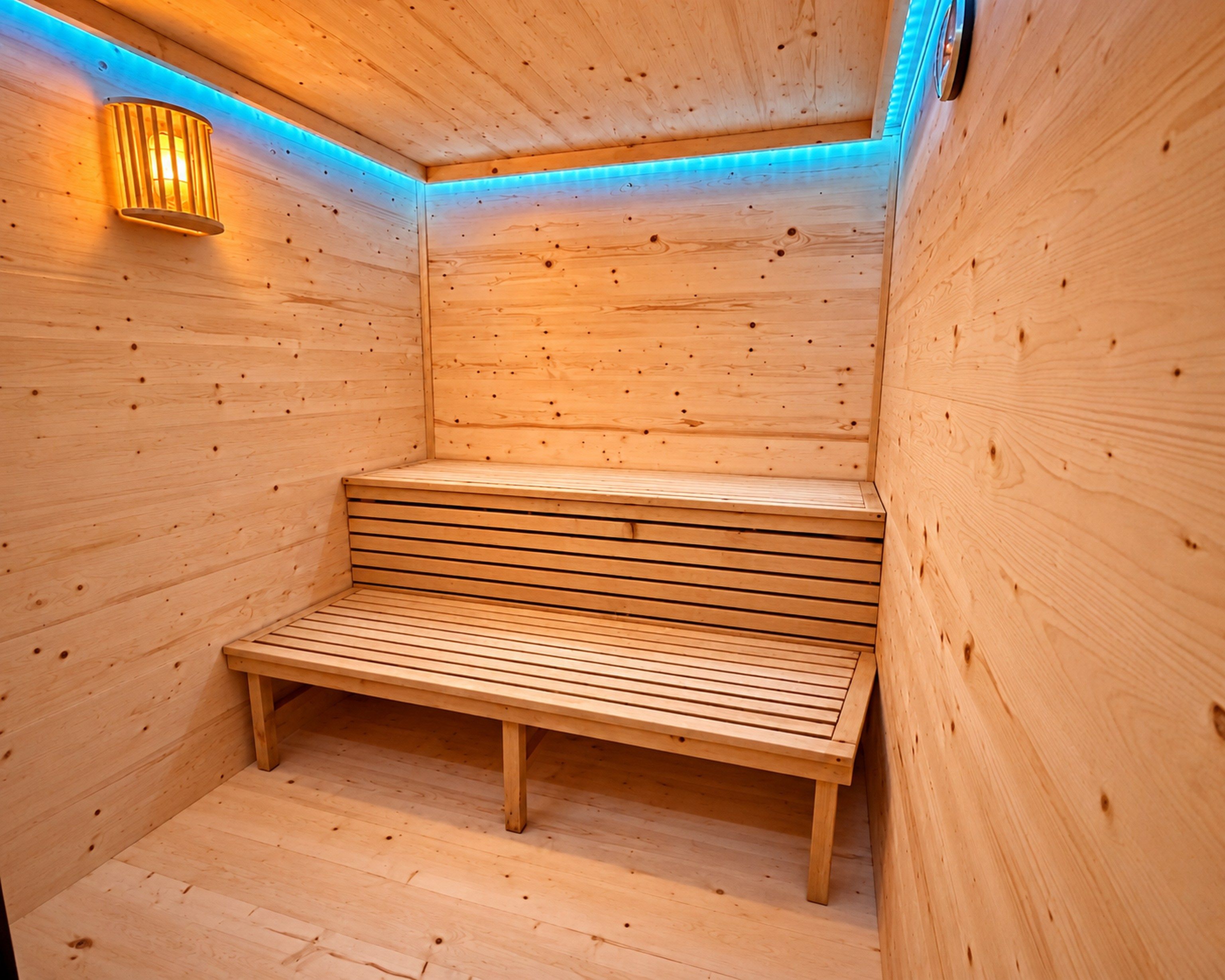 A wooden sauna with a bench and a wall-mounted light fixture.