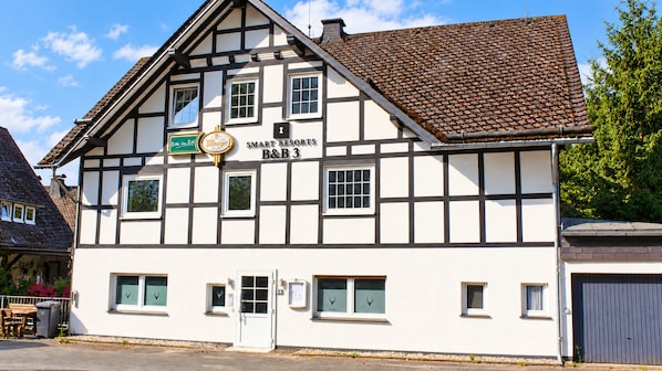 A traditional half-timbered building with a sign for 'SMART RESORTS B&B 3' and a beer sign. - Comfortable and versatile room-perfect for relaxation, work and exchange (Winterberg)