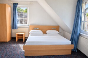 A bedroom with a bed, a small table, a wardrobe, and a window with curtains. - Comfortable and versatile room-perfect for relaxation, work and exchange (Winterberg)