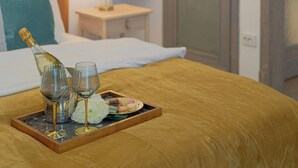 Habitación de hotel con cama, mesita de noche con lámpara, puerta y una pequeña planta en maceta en la pared.