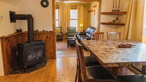 Un salon chaleureux avec une cheminée, des meubles en bois et un coin repas.