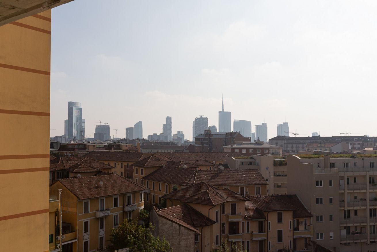 A cityscape with residential buildings and high-rise structures, including a prominent skyscraper.