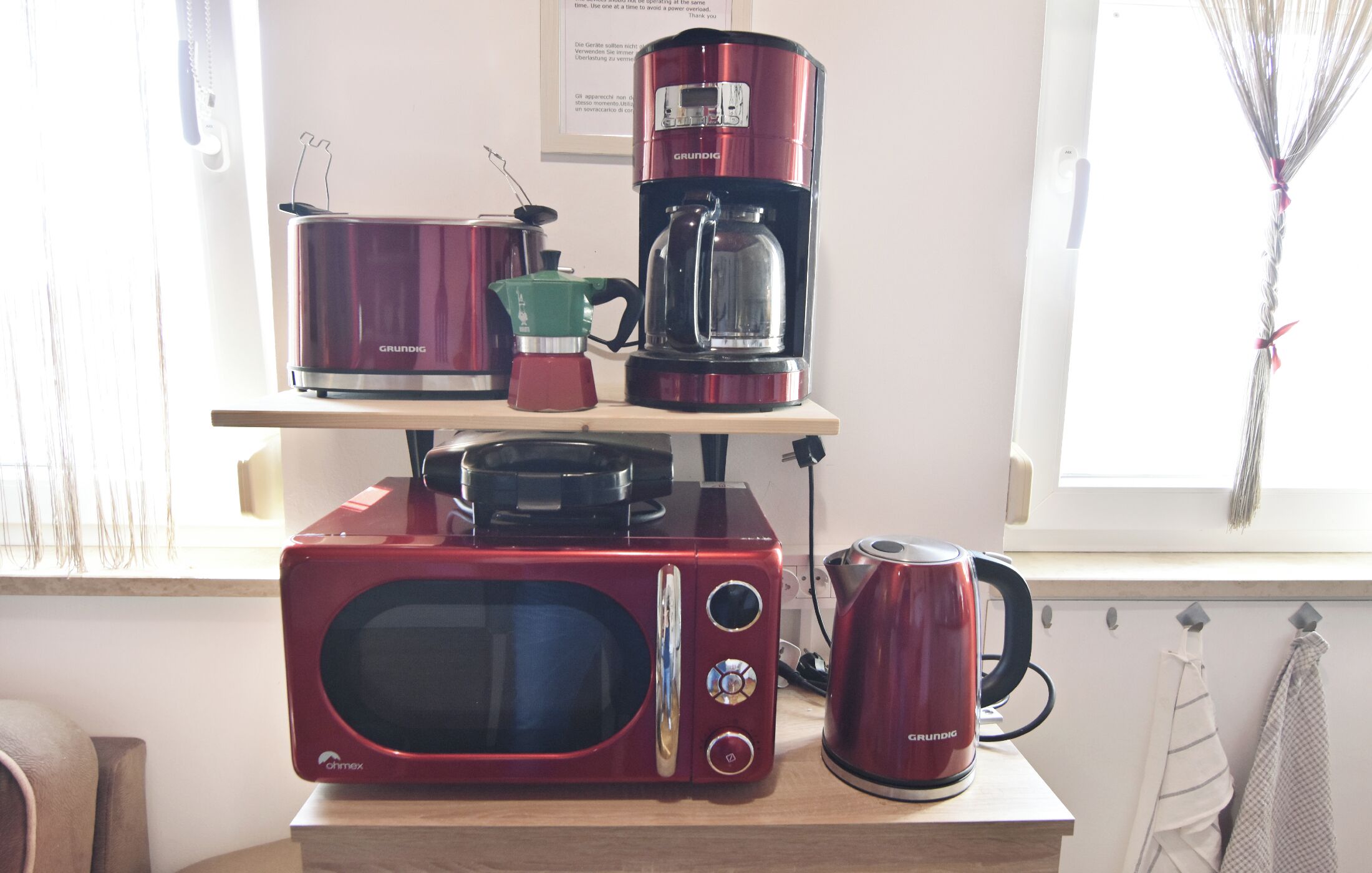 Une cuisine équipée d’un four à micro-ondes, d’une machine à café et d’une casserole rangée sur une étagère.
