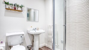 Ein modernes Badezimmer mit Toilette, Waschtisch und Duschkabine.
