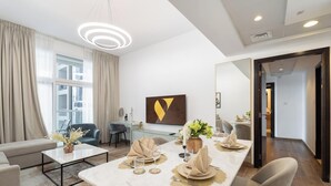 Een moderne hotelkamer met een zithoek, een bank, een salontafel en een grote spiegel.