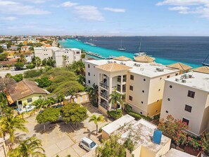 Un quartier résidentiel situé sur la côte, avec des immeubles, un port de plaisance et une vue dégagée sur la mer.