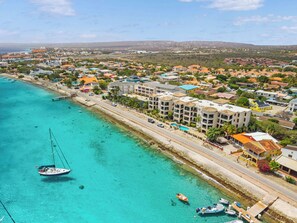 Une ville côtière dotée d’un port de plaisance, de bâtiments le long de la côte et d’eaux turquoise et cristallines.