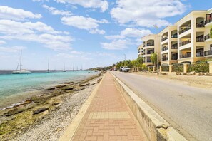 A coastal road with a paved walkway alongside a rocky shoreline. - Elegancia Ocean View with Cooling Pool (Kralendijk)