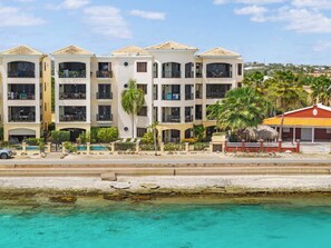 A multi-story hotel with balconies, a swimming pool, and a view of the sea. - Elegancia Ocean View with Cooling Pool (Kralendijk)