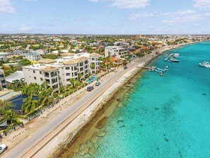 A coastal hotel with multiple floors, a swimming pool, and a beachside location. - Elegancia Ocean View with Cooling Pool (Kralendijk)