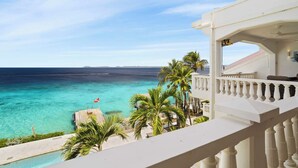 Un balcon donnant sur une mer turquoise et un ciel dégagé.