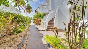 Un chemin menant à un bâtiment blanc doté d’un escalier en colimaçon.