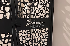Eine Tür mit schwarzem Rahmen und weißen abstrakten Mustern, beschriftet mit "Bonaire Beach".
