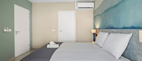 Une chambre d’hôtel équipée d’un lit, d’un ventilateur de plafond, d’un appareil de climatisation et d’un mur au décor texturé.