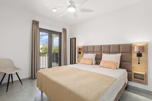 A modern bedroom with a large bed, a ceiling fan, and a view of the outdoors through a sliding door.