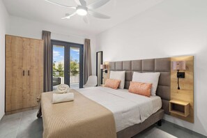Ein Schlafzimmer mit Bett, Kleiderschrank, Deckenventilator und Blick durch das Fenster.