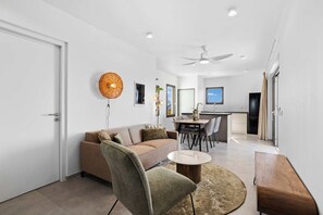 Un salon moderne avec un canapé, une table à manger et un ventilateur de plafond.