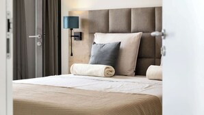 A hotel room with a bed, a nightstand, a lamp, and a door. - Bonaire Beach Apartments 15 with a refreshing shared pool and spectacular sea view (Kralendijk)