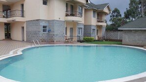 Una piscina rodeada por un edificio de ladrillo con balcones.
