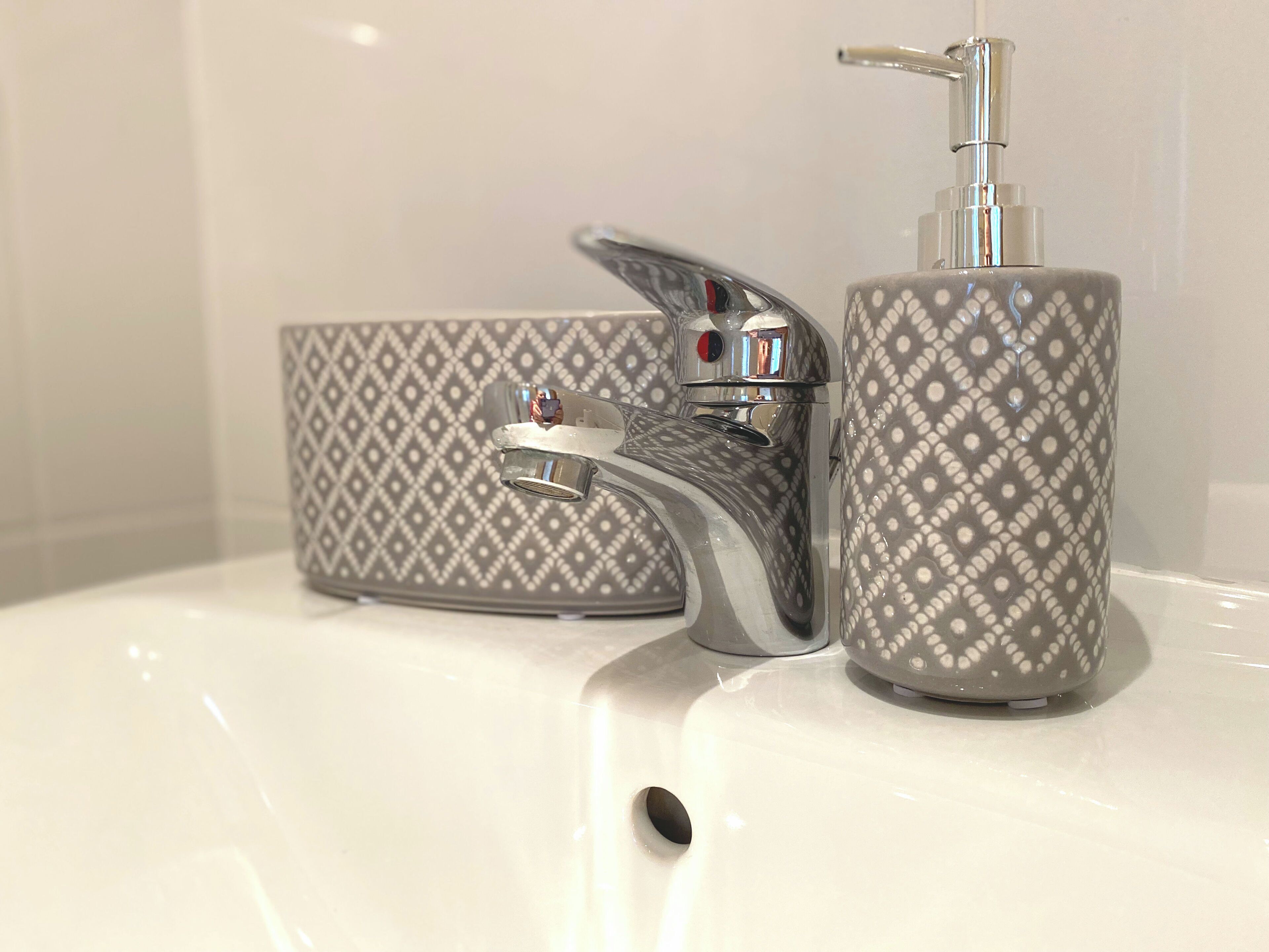 Ein Waschtisch mit modernem Wasserhahn und Seifenspender.