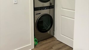 Une buanderie équipée de deux machines à laver à chargement frontal superposées.