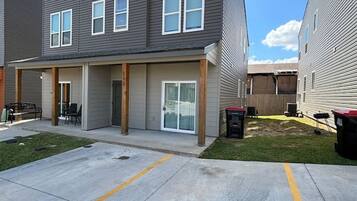 Un immeuble résidentiel moderne à plusieurs étages, doté d’un toit plat, de grandes fenêtres et d’un patio couvert.