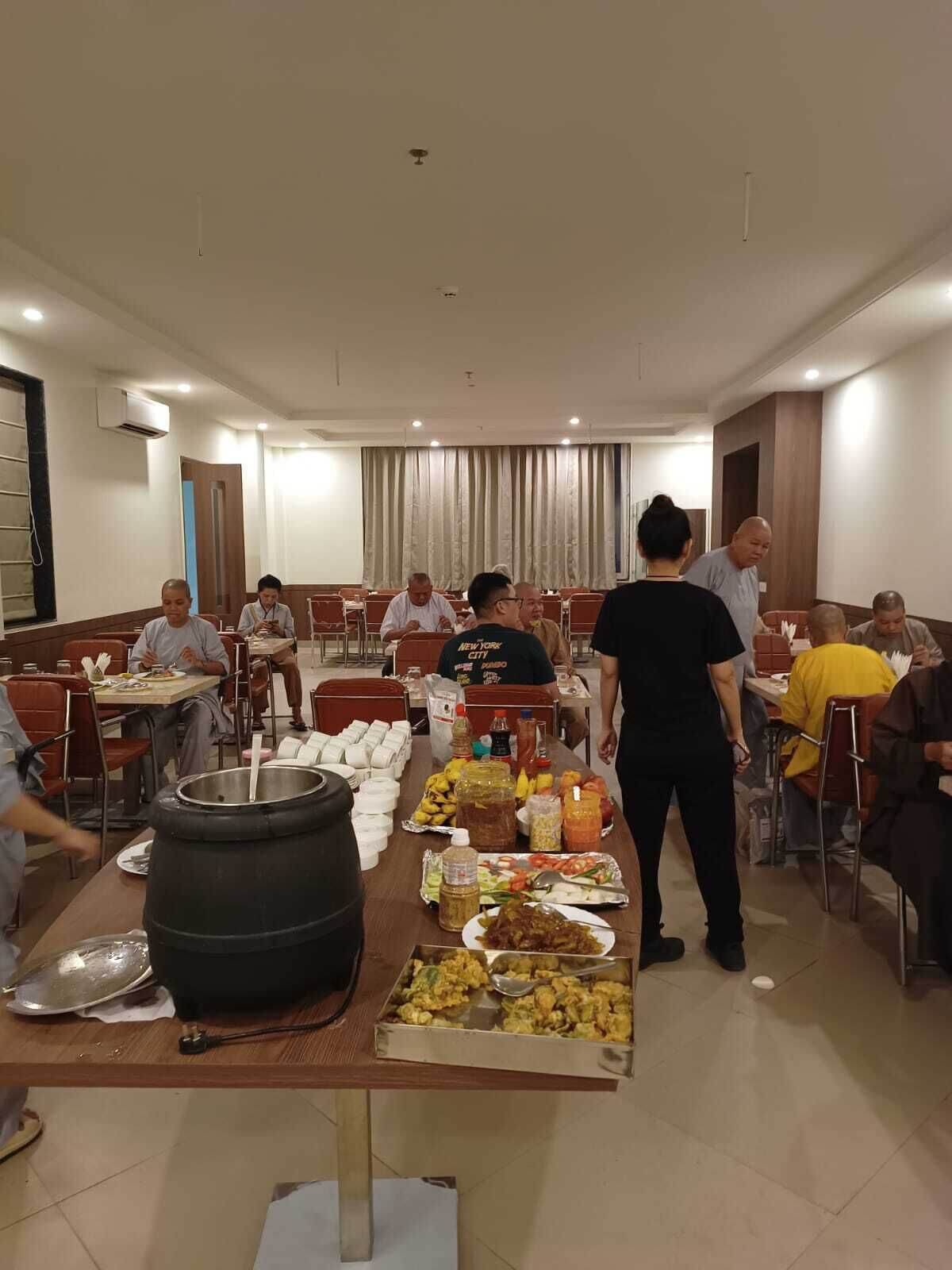 A dining area with tables, chairs, and a buffet table with various food items.