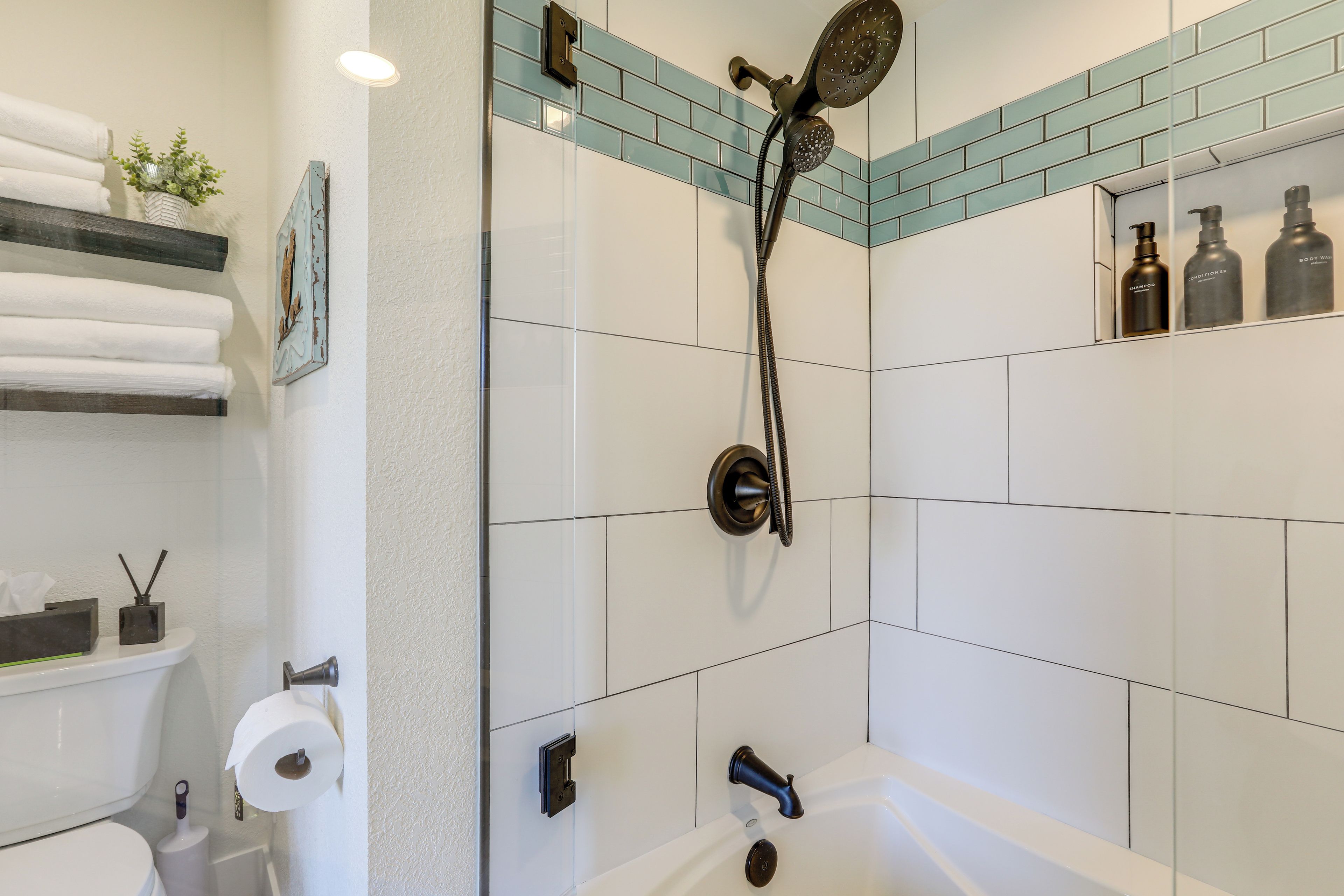 A bathroom with a shower, toilet, and sink.