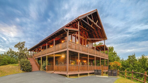 A two-story log cabin with a balcony, a covered porch, and a driveway. - Hot Tub + Games! Mtn-view Cabin Near Pigeon Forge (Sevierville)