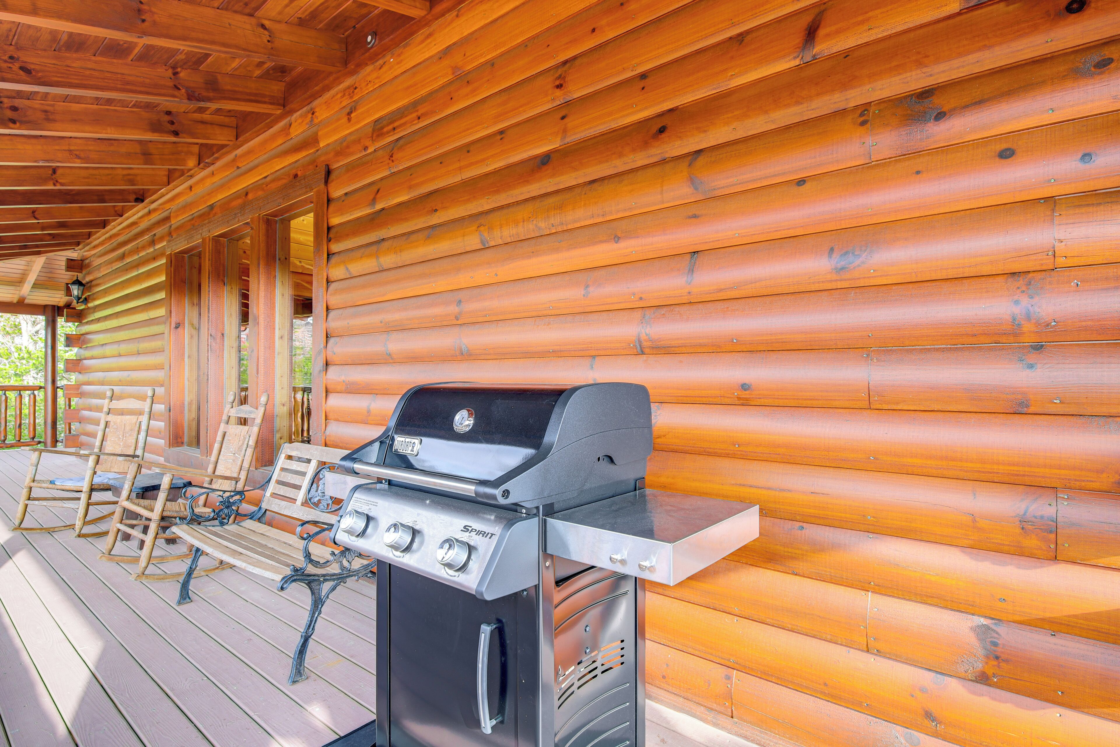 A wooden cabin with a barbecue grill on the porch.