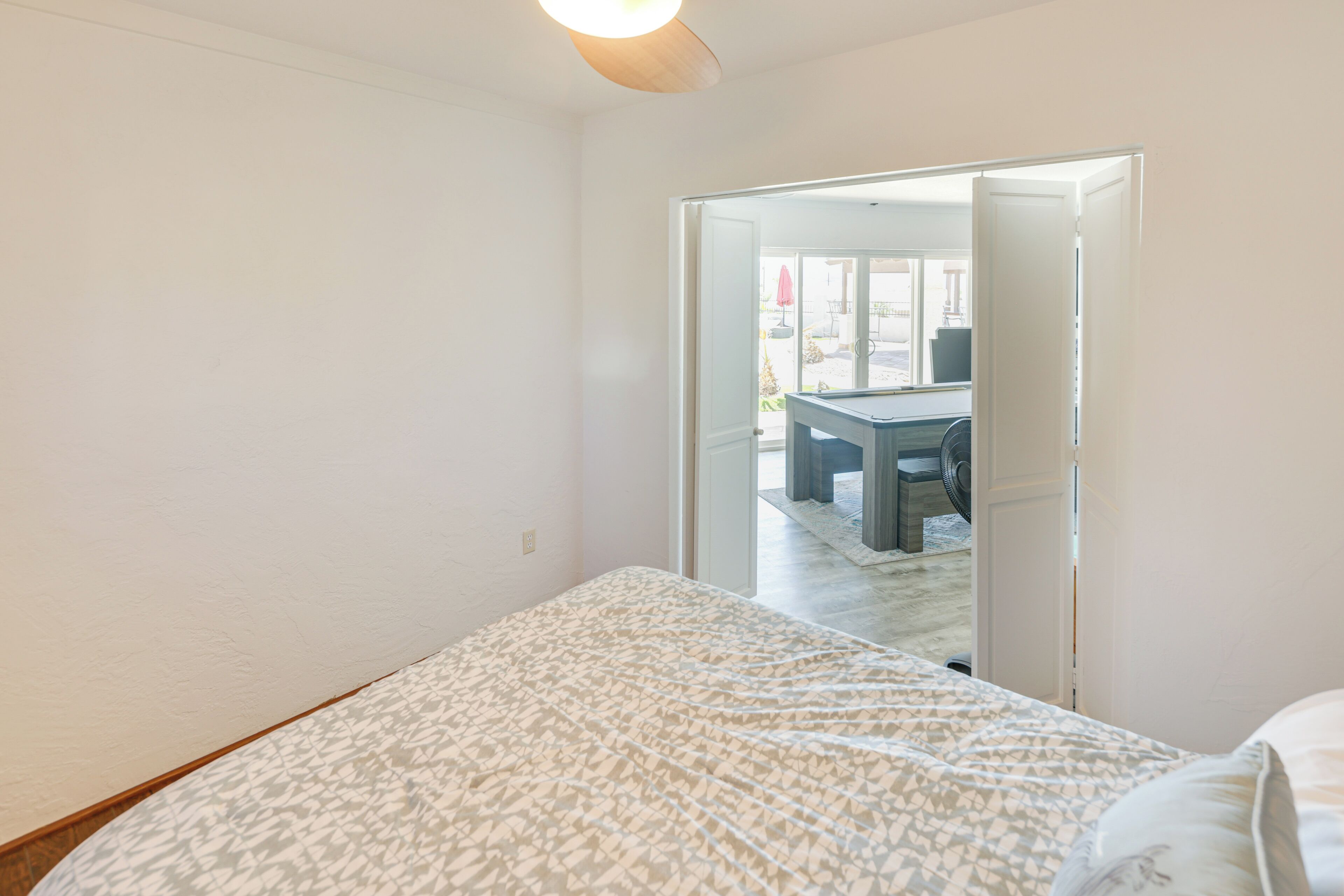 Un dormitorio con una cama, una puerta que da a un balcón y vistas al exterior.