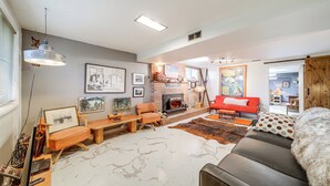 Ein Wohnzimmer mit Kamin, einer Couch, einem Couchtisch und einem Teppich.