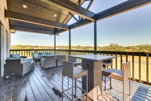 A covered outdoor patio with wicker furniture and a view of the landscape. - Walk to Water: Game Room at Buchanan Dam Home! (Buchanan Dam)