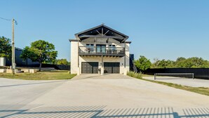 Un bâtiment à deux étages doté d’un balcon à l’étage supérieur, de grandes portes de garage et d’un ciel dégagé.