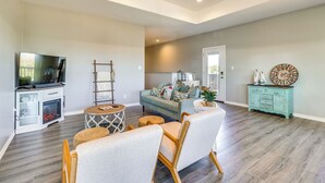 Un salon spacieux avec une cheminée, un téléviseur et un coin salon confortable.