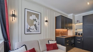 A modern living room with a sofa, red cushions, and a framed artwork on the wall. - Eiffel Tower Apartment Invalides (Paris)