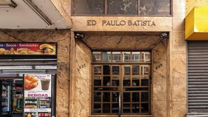 Un escaparate con un letrero que dice 'ED PAULO BATISTA' y una exhibición de alimentos, incluyendo sándwiches y bebidas.